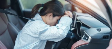 Araba kullanırken gergin ve sinirli bir kadın. Asyalı kız trafikte araba kullandıktan sonra yorgun ve yorgun düşüyor. Uykulu, esnetici ve sarhoş konsepti