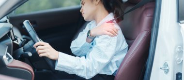 Uzun süre araba kullanırken omzu ve boynu burkulmuş bir kadın. Kas ağrısı çekiyor. Omuz ağrısı, skapüler ağrı, ofis sendromu ve ergonomik konsept.
