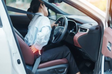 Uzun süre araba kullanırken sırtı burkulmuş bir kadın. Piriforis Sendromu, bel ağrısı ve omurga sıkışması nedeniyle sırt ağrısı çekiyor. Ergonomik ve tıbbi konsept