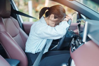 Araba kullanırken gergin ve sinirli bir kadın. Asyalı kız trafikte araba kullandıktan sonra yorgun ve yorgun düşüyor. Uykulu, esnetici ve sarhoş konsepti