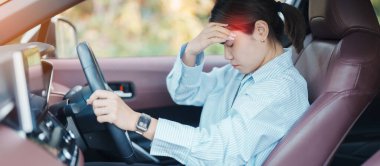 Araba kullanırken gergin ve sinirli bir kadın. Asyalı kız trafikte araba kullandıktan sonra yorgun ve yorgun düşüyor. Uykulu, esnetici ve sarhoş konsepti