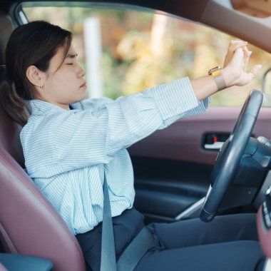 woman feeling sleepy and yawn during drive car long time. Asian girl tired and fatigue having headache after driving car in traffic jam. Sleep, stretching and safety concept clipart