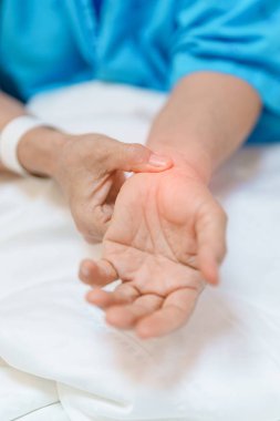 Hastanede bilek ağrısı çeken yaşlı bir kadın, Karpal Tünel Sendromu nedeniyle kas ağrısı, De Quervain 's tenosynovitis, romatoid, artrit, gut, Parkinson hastalığı ve ergonomik sağlık hizmetleri 