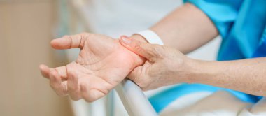 Hastanede bilek ağrısı çeken yaşlı bir kadın, Karpal Tünel Sendromu nedeniyle kas ağrısı, De Quervain 's tenosynovitis, romatoid, artrit, gut, Parkinson hastalığı ve ergonomik sağlık hizmetleri 