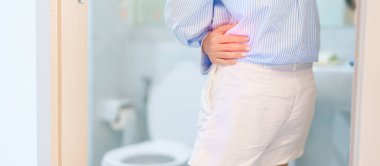 Kadın tuvalette mide ağrısı ya da mide ağrısı yaşıyor. Gıda zehirlenmesi, kabızlık, viral gastroenterit, çölyak hastalığı ve malabsorpsiyon yüzünden kronik ishal. Sağlık Hizmetleri 