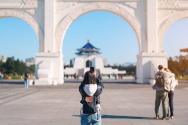 Tayvan 'da seyahat eden bir kadın gezgin, Taipei City' deki Hall Freedom Square 'de, National Chiang Kai shek Memorial' da cep telefonuyla fotoğraf çeken bir bayan turist. Popüler dönüm noktası ve gösteriler