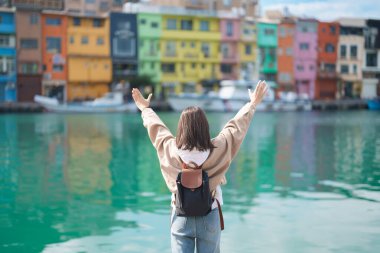 Tayvan 'a gezmeye gelen kadın gezgin, Keelung, Renkli Zhengbin Balıkçılık Limanı' nda sırt çantasıyla gezen kadın turist. Taipei şehrinin yakınlarındaki popüler yerler ve eğlence yerleri. Asya Seyahat Konsepti