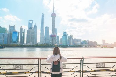 Çin, Şangay 'ı ziyaret eden bir kadın gezgin. Sırt çantalı bayan turist Şangay 'ın kuzeyindeki Lujiazui' nin Şangay manzarasına bakıyor. tarihi eser ve turizm turizmi için popüler.