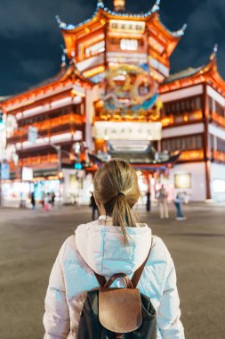 Çin, Şangay 'ı ziyaret eden bir kadın gezgin. Gece Yuyuan Eski Sokak pazarında mutlu bayan turist gezileri ve alışverişleri. Şehir simgesi ve turizm turizmi için popüler. Seyahat ve Tatil 