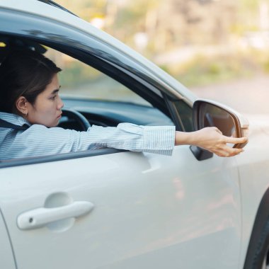 İş kadını sürücüsü yan aynada bir arabayı ayarlıyor. Yolculuk, yolculuk ve güvenlik ulaşım kavramları