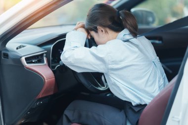 Araba kullanırken gergin ve sinirli bir kadın. Asyalı kız trafikte araba kullandıktan sonra yorgun ve yorgun düşüyor. Uykulu, esnetici ve sarhoş konsepti