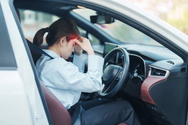 Araba kullanırken gergin ve sinirli bir kadın. Asyalı kız trafikte araba kullandıktan sonra yorgun ve yorgun düşüyor. Uykulu, esnetici ve sarhoş konsepti