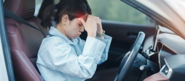 Araba kullanırken gergin ve sinirli bir kadın. Asyalı kız trafikte araba kullandıktan sonra yorgun ve yorgun düşüyor. Uykulu, esnetici ve sarhoş konsepti