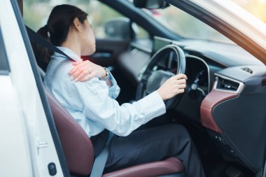 Uzun süre araba kullanırken omzu ve boynu burkulmuş bir kadın. Kas ağrısı çekiyor. Omuz ağrısı, skapüler ağrı, ofis sendromu ve ergonomik konsept.