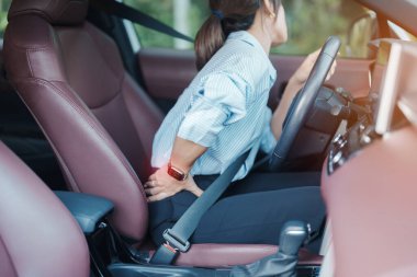 Uzun süre araba kullanırken sırtı burkulmuş bir kadın. Piriforis Sendromu, bel ağrısı ve omurga sıkışması nedeniyle sırt ağrısı çekiyor. Ergonomik ve tıbbi konsept