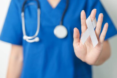 Beyin Kanseri Farkındalığı Mayıs ayında, gri renkli kurdeleli doktor, yaşam insanlarını desteklediği için. Sağlık ve Dünya Kanser Günü konsepti