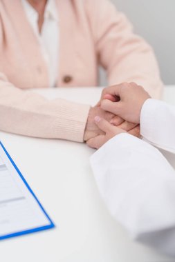 Hastanedeki doktora danışmanlık yapan kıdemli bir kadın. Yaşlı hasta konuşuyor ve hastalıkları paylaşıyor. Doktor dinler, soru sorar ve not alır. Tıbbi danışmanlık ve yaşlılık sağlığı konsepti 