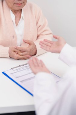 Hastane randevusu sırasında yaşlı hastaya teşhis ve tedavi planını açıklayan doktor. Kıdemli hasta doktordan hastalığa konuşuyor. Tıbbi danışmanlık, yaşlılık bakımı, sağlık konsepti 