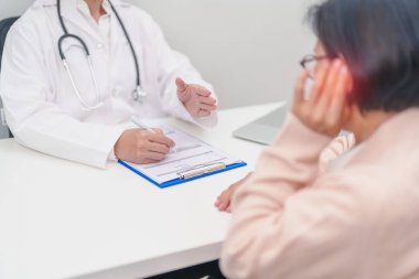 Kulak ağrısı olan yaşlı kadın hasta ve kulak hastalıkları için doktora danışmak. Kıdemli Sağlık Teşhisi. Atresia, Otitis Media, Pertorated Eardrum, Meniere Sendromu, otolaryngologist, İşitme Kaybı