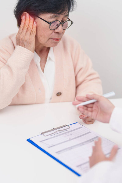 Пожилая женщина Пациентка, страдающая ушной болью и консультирующая доктора по поводу болезни уха. Медицинская диагностика для пожилых людей. Атрезия, отит, перелом барабанной перепонки, менструальный синдром, отоларинголог, легочная гипертензия