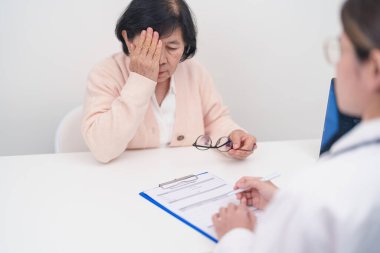 Yaşlı kadın hasta göz ağrısı çekiyor ve göz hastalıkları doktoruna danışıyor. Kıdemli Tıbbi Teşhis. Katarakt, glikoma, Yaşla İlgili Maküler Dejenerasyon, Diyabetik Retinopati, Vitreöz ve Sağlık 