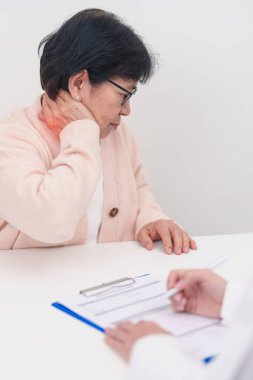 Omuz ve Boyun 'u olan yaşlı kadın ve hastanede danışman doktor. Miyofasyal ağrı sendromu, fibromiyalji, romatizma, skapüler ağrı, boyun omurgası. ergonomik kavram