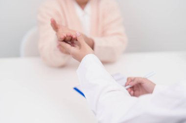 Yaşlı Hasta Kadın bilek ağrısı ve danışman doktor. Karpal Tünel Sendromu, De Quervain 's tenosilovitis, romatizma, artrit, gut, Parkinson hastalığı ve ergonomik sağlık sigortası yüzünden kas ağrısı. 