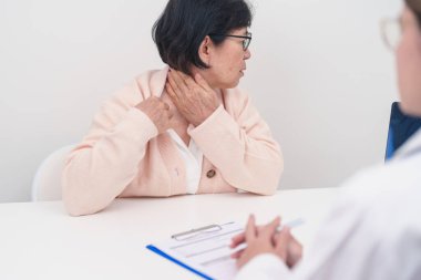 Omuz ve Boyun 'u olan yaşlı kadın ve hastanede danışman doktor. Miyofasyal ağrı sendromu, fibromiyalji, romatizma, skapüler ağrı, boyun omurgası. ergonomik kavram