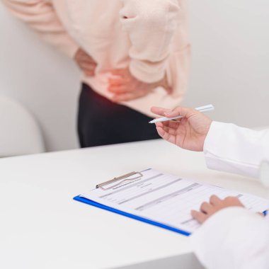 Yaşlı bir kadın sırt ağrısı çekiyor ve hastanede danışmanlık yapıyor. Piriforis Sendromu, bel ağrısı ve omurga baskısı nedeniyle kas ağrısı olan yaşlı bir kadın. Ofis sendromu ve tıbbi 