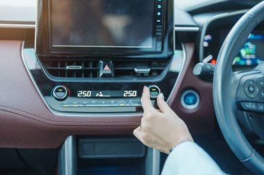 Kadın eli ısıyı ayarlıyor araba kullanırken hava akışı, arabanın içindeki klima soğutma sistemi. Ayarlama, sıcaklık ve ulaşım kavramı