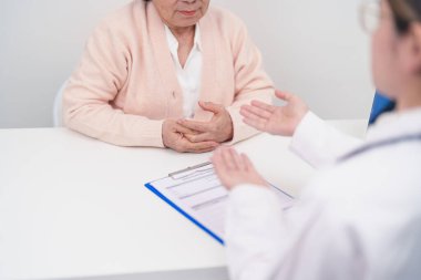 Hastane randevusu sırasında yaşlı hastaya teşhis ve tedavi planını açıklayan doktor. Kıdemli hasta doktordan hastalığa konuşuyor. Tıbbi danışmanlık, yaşlılık bakımı, sağlık konsepti 