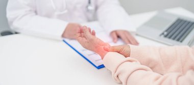 Yaşlı Hasta Kadın bilek ağrısı ve danışman doktor. Karpal Tünel Sendromu, De Quervain 's tenosilovitis, romatizma, artrit, gut, Parkinson hastalığı ve ergonomik sağlık sigortası yüzünden kas ağrısı. 