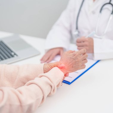Yaşlı Hasta Kadın bilek ağrısı ve danışman doktor. Karpal Tünel Sendromu, De Quervain 's tenosilovitis, romatizma, artrit, gut, Parkinson hastalığı ve ergonomik sağlık sigortası yüzünden kas ağrısı. 