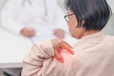 Omuz ve Boyun 'u olan yaşlı kadın ve hastanede danışman doktor. Miyofasyal ağrı sendromu, fibromiyalji, romatizma, skapüler ağrı, boyun omurgası. ergonomik kavram