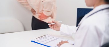 Yaşlı bir kadın sırt ağrısı çekiyor ve hastanede danışmanlık yapıyor. Piriforis Sendromu, bel ağrısı ve omurga baskısı nedeniyle kas ağrısı olan yaşlı bir kadın. Ofis sendromu ve tıbbi 