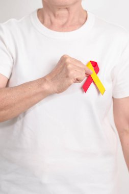 Dünya Hepatit Günü farkındalık ayı, 28 Temmuz. Kırmızı ve sarı kurdeleli yaşlı kadın. Karaciğer kanseri, sarılık, siroz, başarısızlık, büyüme, Hepatik Ensefalopati ve Sağlık Konsepti