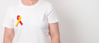 Dünya Hepatit Günü farkındalık ayı, 28 Temmuz. Kırmızı ve sarı kurdeleli yaşlı kadın. Karaciğer kanseri, sarılık, siroz, başarısızlık, büyüme, Hepatik Ensefalopati ve Sağlık Konsepti