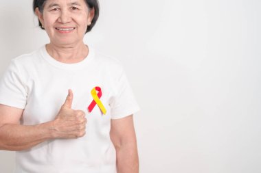 Dünya Hepatit Günü farkındalık ayı, 28 Temmuz. Kırmızı ve sarı kurdeleli yaşlı kadın. Karaciğer kanseri, sarılık, siroz, başarısızlık, büyüme, Hepatik Ensefalopati ve Sağlık Konsepti