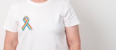 Haziran Gurur Ayı, Nisan Otizm Bilinci, Kanser Farkındalığı, Şubat Dünya Kanser Günü, Ekim Dünya Bakımevi ve Palyatif Bakım Günü konsepti için LGBTQ Gökkuşağı kurdelesine sahip yaşlılar