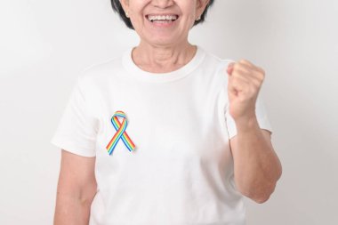 Haziran Gurur Ayı, Nisan Otizm Bilinci, Kanser Farkındalığı, Şubat Dünya Kanser Günü, Ekim Dünya Bakımevi ve Palyatif Bakım Günü konsepti için LGBTQ Gökkuşağı kurdelesine sahip yaşlılar