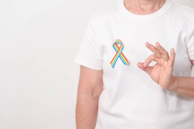 Haziran Gurur Ayı, Nisan Otizm Bilinci, Kanser Farkındalığı, Şubat Dünya Kanser Günü, Ekim Dünya Bakımevi ve Palyatif Bakım Günü konsepti için LGBTQ Gökkuşağı kurdelesine sahip yaşlılar