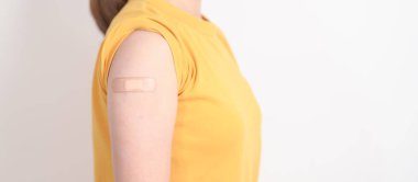 Aşı olduktan sonra bandajlı yetişkin kadın. Grip aşısı, HPV, Zoster, IPD, DTP veya Difteri, Tetanos ve Pertusis, MMR, Hepatit B, Covid ve Varicella aşısı