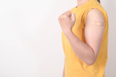 Aşı olduktan sonra bandajlı yetişkin kadın. Grip aşısı, HPV, Zoster, IPD, DTP veya Difteri, Tetanos ve Pertusis, MMR, Hepatit B, Covid ve Varicella aşısı