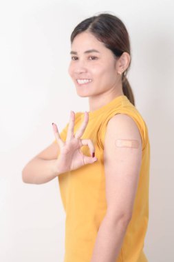 Aşı olduktan sonra bandajlı yetişkin kadın. Grip aşısı, HPV, Zoster, IPD, DTP veya Difteri, Tetanos ve Pertusis, MMR, Hepatit B, Covid ve Varicella aşısı