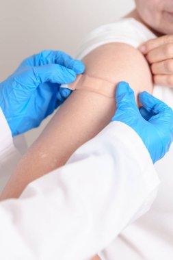 Elderly Woman with bandage after received vaccine. Vaccination and Immunization for Influenza, Herpes Zoster, Tetanus, Covid 19 booster, Dengue, Encephalitis, Rabies, Pneumococcal, IPD, RSV Vaccines 