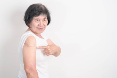 Elderly Woman with bandage after received vaccine. Vaccination and Immunization for Influenza, Herpes Zoster, Tetanus, Covid 19 booster, Dengue, Encephalitis, Rabies, Pneumococcal, IPD, RSV Vaccines 