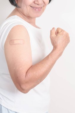 Elderly Woman with bandage after received vaccine. Vaccination and Immunization for Influenza, Herpes Zoster, Tetanus, Covid 19 booster, Dengue, Encephalitis, Rabies, Pneumococcal, IPD, RSV Vaccines 