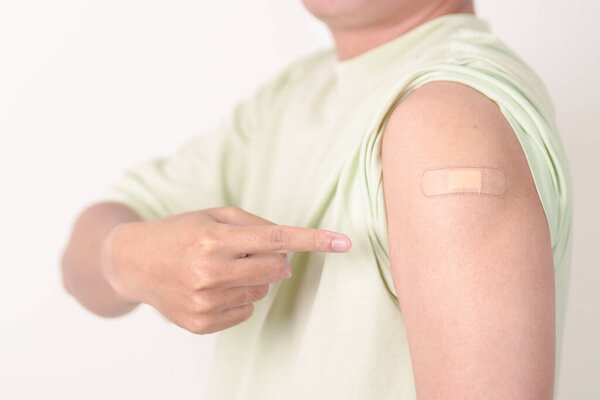 Adult Man with bandage after received vaccine. Vaccination and Immunization for Influenza, HPV, Zoster, IPD, DTP or Diphtheria, Tetanus and Pertussis, MMR, Hepatitis B, Covid and Varicella vaccine