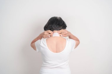 Boynu ağrıyan yaşlı bir kadın boyun ağrısı için boyun ağrısı bandı ve iltihaplanma, miyofasyal ağrı sendromu ve fibromiyalji, romatizma ve boyun omurilik spondilozu. 