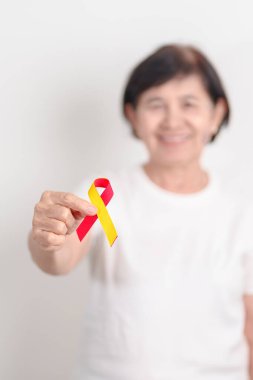 Dünya Hepatit Günü farkındalık ayı, 28 Temmuz. Kırmızı ve sarı kurdeleli yaşlı kadın. Karaciğer kanseri, sarılık, siroz, başarısızlık, büyüme, Hepatik Ensefalopati ve Sağlık Konsepti